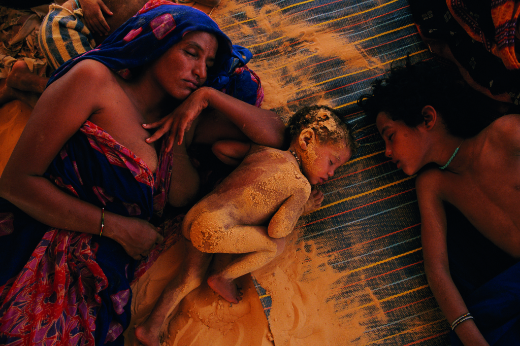 2. Joanna Pinneo Mali 1997 Coperta da un velo di sabbia proveniente dal letto asciutto di un lago, una famiglia fa un sonnellino in pieno pomeriggio.
